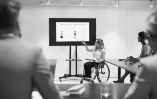 woman in wheelchair giving presentation to colleagues