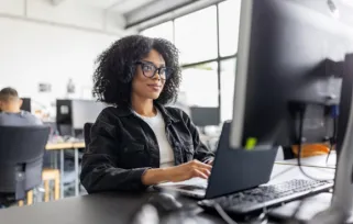 woman sitting in office at desk on her laptop