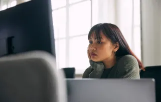 woman sitting at desk looking at computer