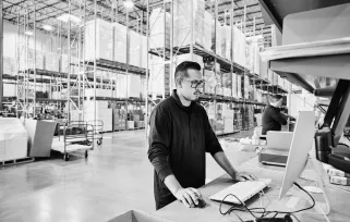 supply chain manager at computer in warehouse
