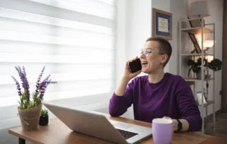 woman on the phone at desk looking happy