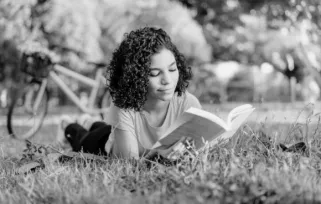 woman lying in the park reading a book