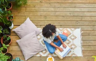 Woman working from home outside in her garden surrounded by plants