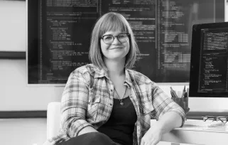 data analyst sitting next to a screen and in front of a data board 