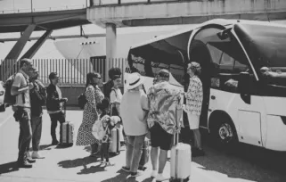 Driver greeting vacationers before boarding motor coach