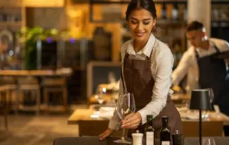 Een vrouw dekt de tafel in een net restaurant.
