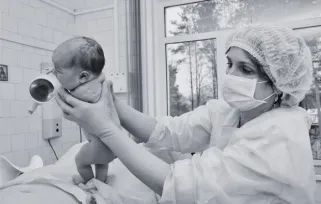 surgeon lifting a baby 