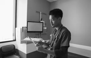 surgical technician standing in tech room with clipboard