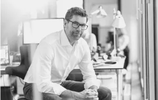 creative director sitting at desk chair with glasses