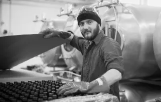 man in factory with gloves on