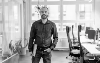 man standing and smiling in office