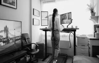 woman working at standing desk on treadmill