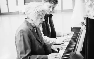 music therapist playing piano with a patient