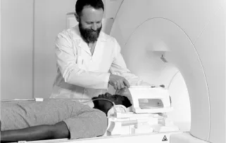 A radiation therapist prepares a patient to enter a linear accelerator