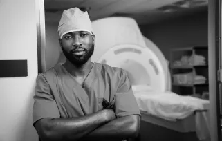 radiologist in scrubs next to MRI machine