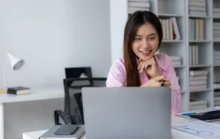 Woman smiling in front of the laptop
