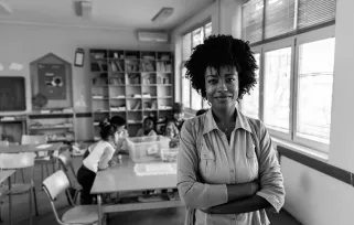teacher standig with arms crossed in classroom