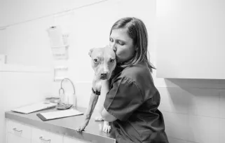 vet tech with dog in exam room