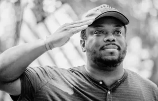 veteran saluting in front of flag