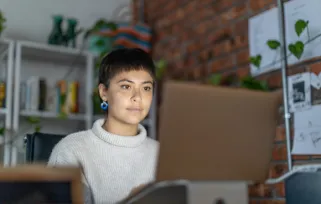 young woman sitting at desk on laptop