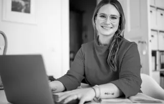 woman sitting at laptop smiling