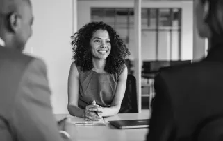 woman smiling in meeting with two others