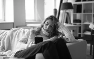 woman sitting on couch on cellphone