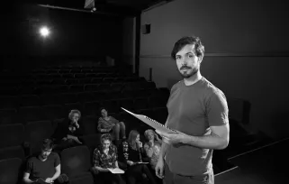 stage manager standing on stage holding paper