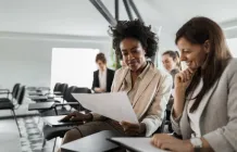 people sitting in office looking at a paper together