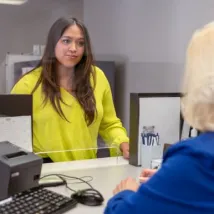 woman speaking to receptionist at bank