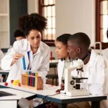Female professor teaching about chemical in test tube to students