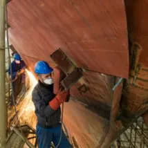 Welding new steel plates on a ship's hull during repair work on a ship in a dry dock